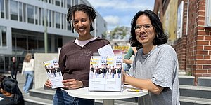 Foto: Stipendiatin und Stipendiat am Infostand auf dem Campus
