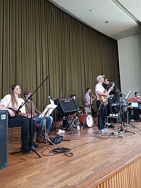 Foto von Musikerinnen und Musikern auf einer Buehne