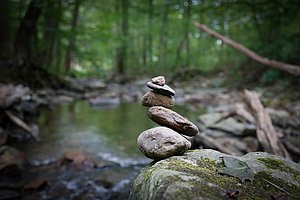 Symbolfoto Balance, Gleichgewicht - Steinturm vor Waldhintergrund