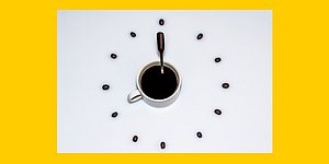 Grafik: Weisses Zifferblatt vor gelbem Hintergrund, Kaffeetasse-Symbol in der Mitte