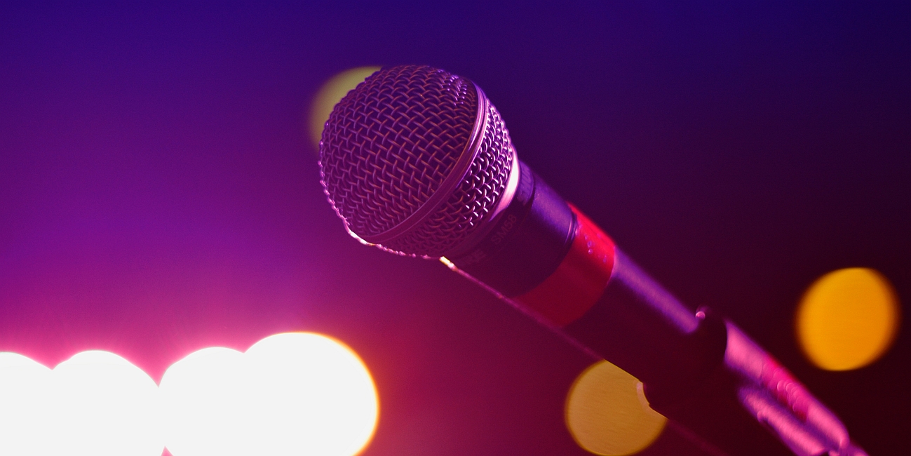 Foto eines Mikrofons vor farbigem Hintergrund