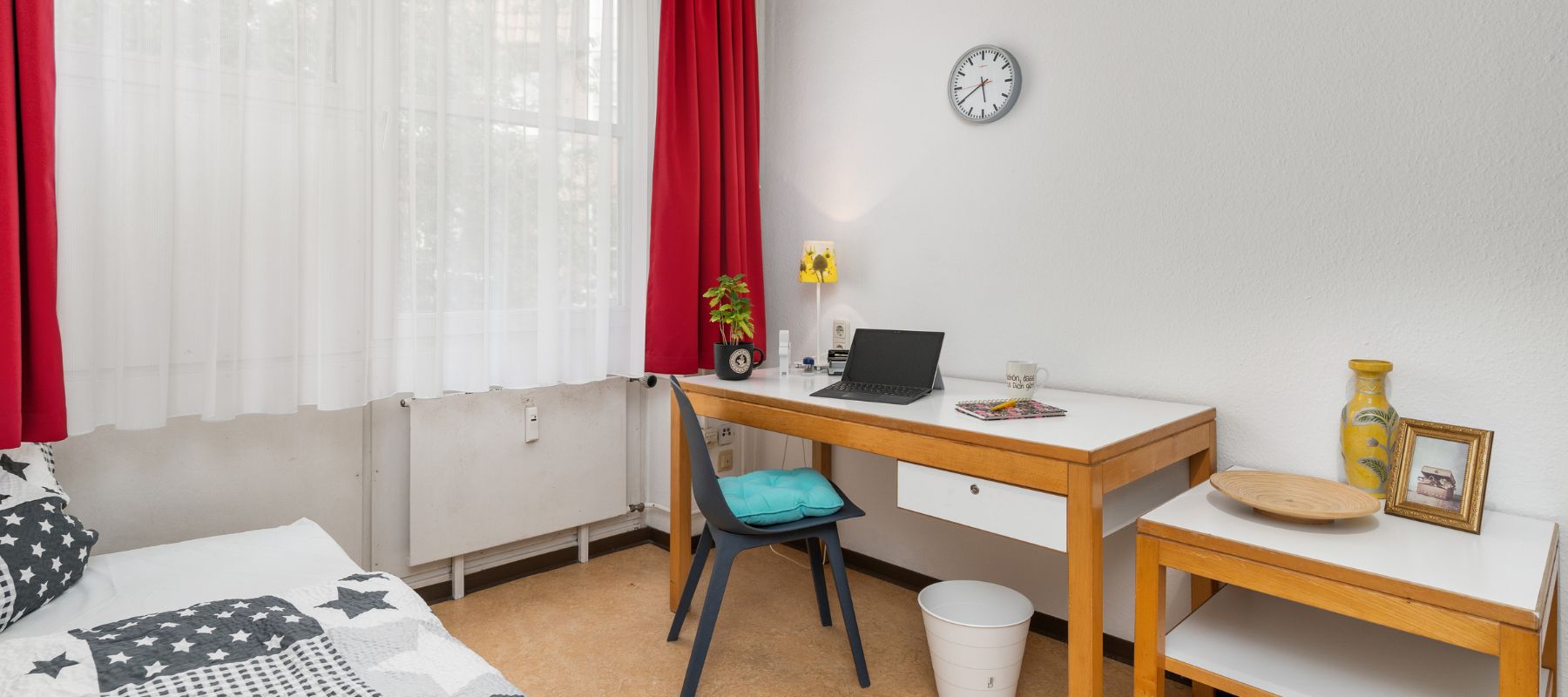 Eingerichtetes Einzelzimmer in WG mit Schreibtisch und Bett.